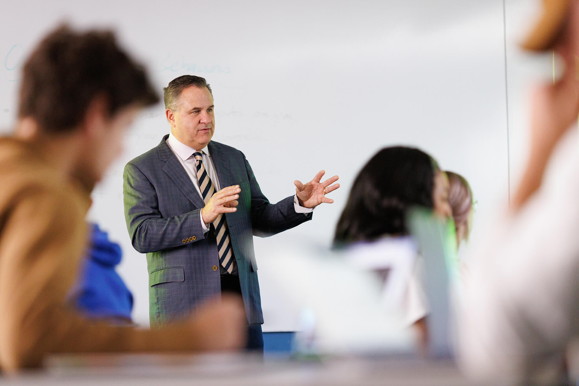 A business professors explains a concept to a small class of students.