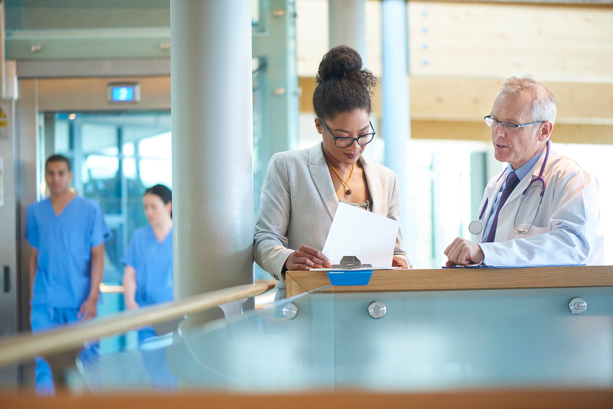 A healthcare professional meets with a doctor at a hospital.