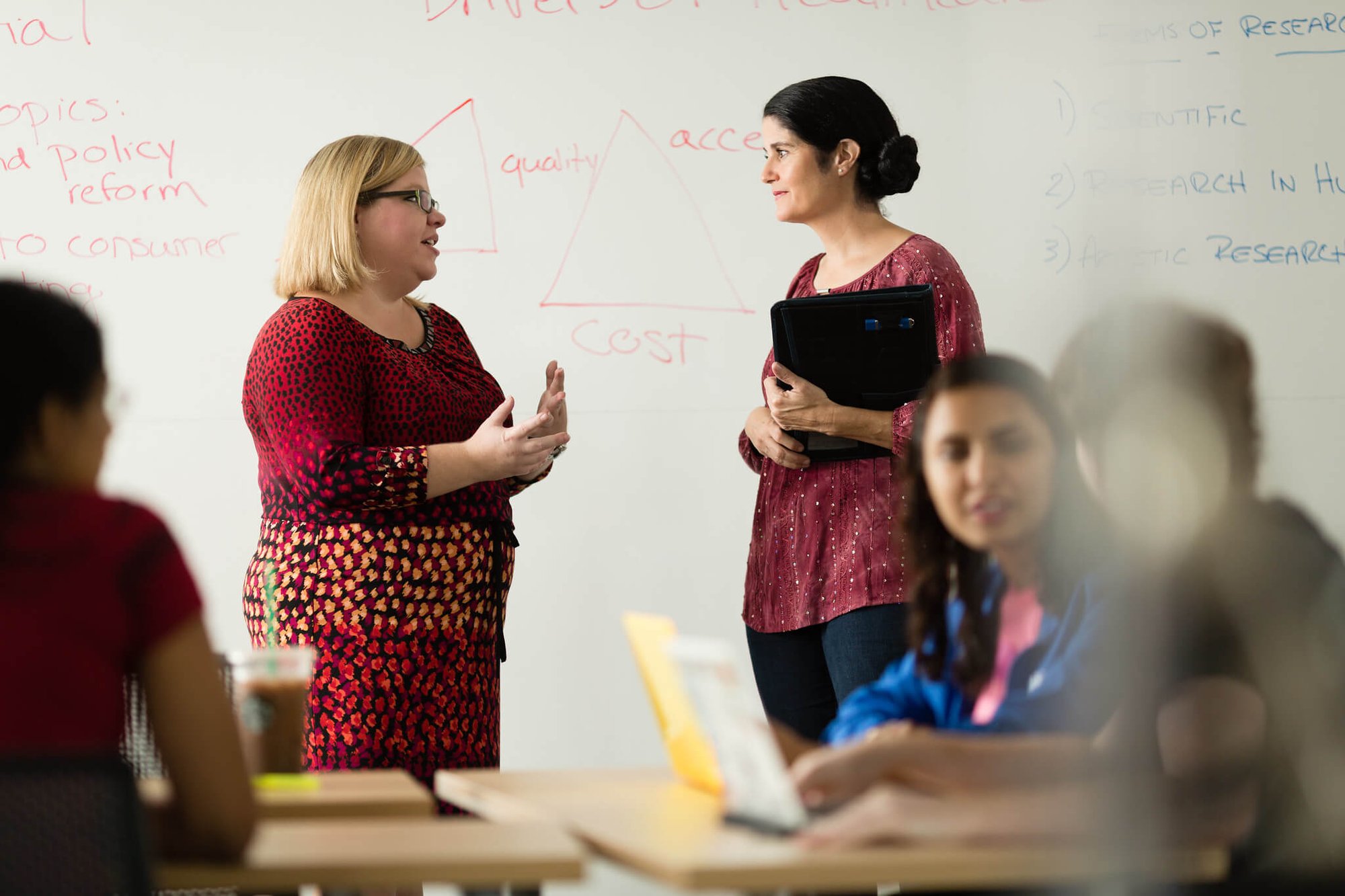 A professor works one on one with a graduate student during class at Rollins College.