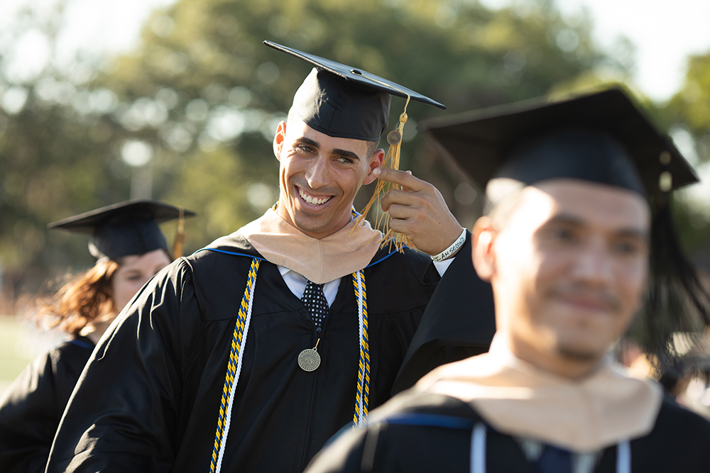 A college graduate smiles after receiving his diploma.